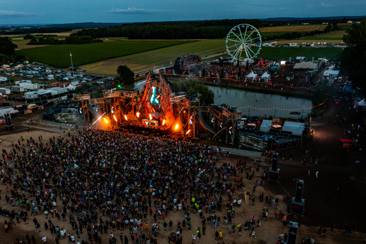 Herzogenaurach Germany 27 July 2025 Aerial view of Open Beatz Festival featuring a massive illuminated stage with fire effects a large crowd of people and a ferris wheel. Herzogenaurach Germany 27 July 2025 Aerial view of Open Beatz Festival featuring a massive illuminated stage with fire effects a large crowd of people and a ferris wheel.