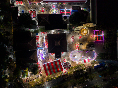 Aerial view of GOR Gelarsena Klaten Night Market with brightly lit amusement rides red and white striped tents and crowds in Kecamatan Klaten Utara Jawa Tengah Indonesia. Aerial view of GOR Gelarsena Klaten Night Market with brightly lit amusement rides red and white striped tents and crowds in Kecamatan Klaten Utara Jawa Tengah Indonesia.