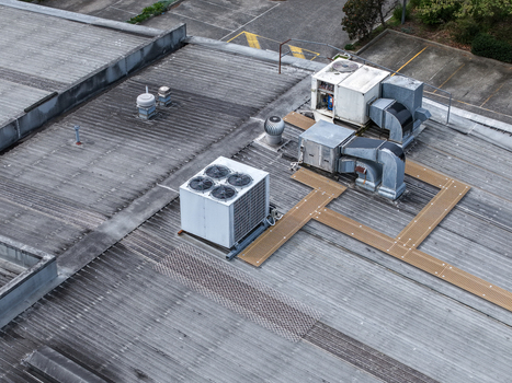 Aerial view of industrial HVAC units and ventilation systems installed on a corrugated metal rooftop in Melbourne VIC Australia.