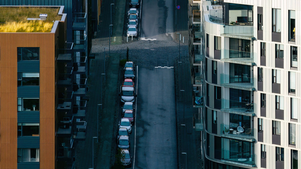 Aerial view of modern apartment complex with balconies and parked cars on a narrow street in Iceland. Aerial view of modern apartment complex with balconies and parked cars on a narrow street in Iceland.