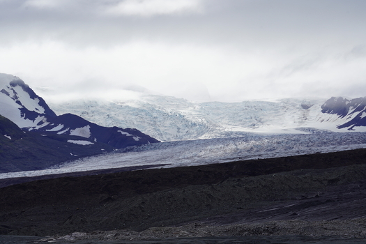 View of Skaftafell glacier with snow capped mountains and dark volcanic terrain Skaftafell Sveitarfelagid Hornaf Iceland. View of Skaftafell glacier with snow capped mountains and dark volcanic terrain Skaftafell Sveitarfelagid Hornaf Iceland.