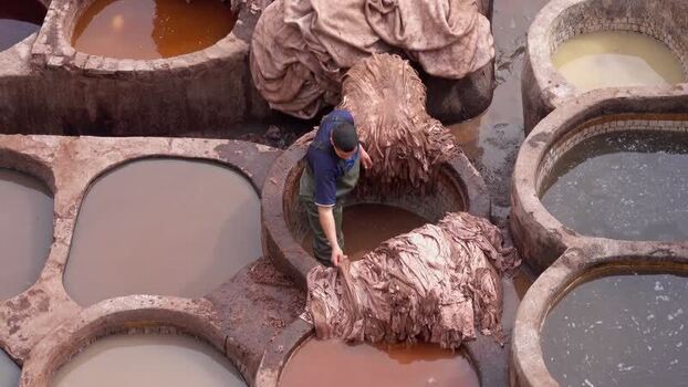 View of a worker at the historic Chouara Tannery in Fes Morocco.