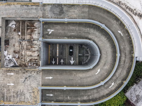 Aerial view of a concrete parking garage ramp with directional arrows and a single parked car in Santo Domingo Distrito Nacional Dominican Republic.