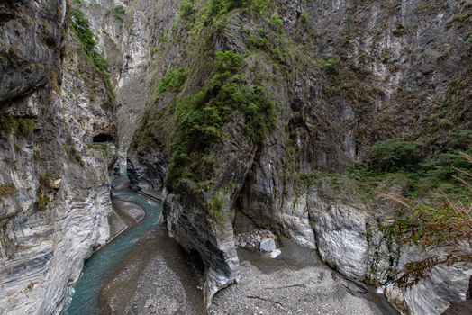 View of Taroko National Park featuring steep marble cliffs a winding river and lush vegetation in Xiulin Township Hualien County Taiwan.