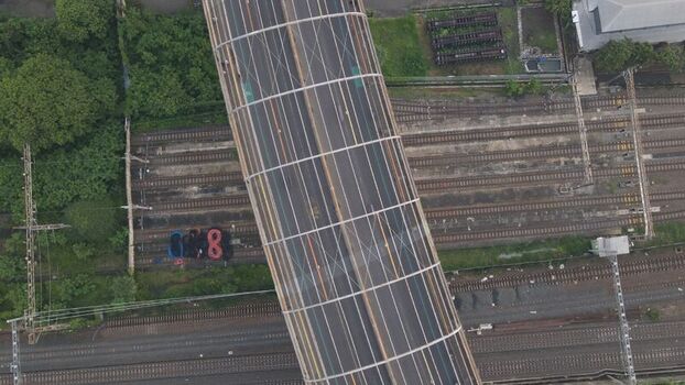 Aerial view of a railway bridge crossing over multiple train tracks in an urban area in Bekasi Barat West Java Indonesia. Aerial view of a railway bridge crossing over multiple train tracks in an urban area in Bekasi Barat West Java Indonesia.