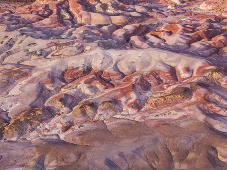 Aerial view of the Bentonite Hills featuring colorful striped clay mounds and desert landscape in Hanksville Utah United States.