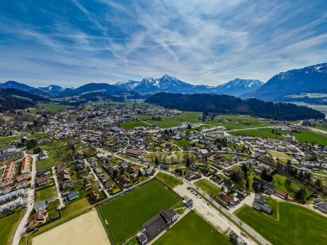 Aerial view of a sprawling town nestled in a lush valley with snow capped mountains rising majestically against a clear blue sky Windischgarsten Upper Austria Austria. Aerial view of a sprawling town nestled in a lush valley with snow capped mountains rising majestically against a clear blue sky Windischgarsten Upper Austria Austria.