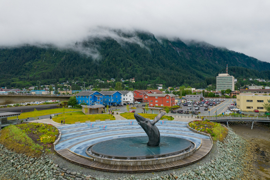 Aerial view of the whale sculpture in a waterfront park with colorful buildings and mountains in the background in Juneau Alaska United States. Aerial view of the whale sculpture in a waterfront park with colorful buildings and mountains in the background in Juneau Alaska United States.