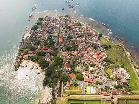Aerial view of Galle Fort with its historic colonial architecture red tiled roofs and defensive walls jutting into the Indian Ocean Galle Southern Province Sri Lanka. Aerial view of Galle Fort with its historic colonial architecture red tiled roofs and defensive walls jutting into the Indian Ocean Galle Southern Province Sri Lanka.