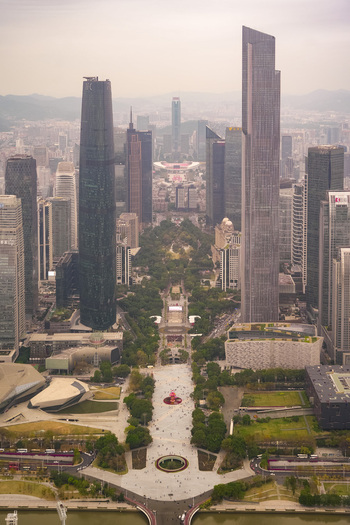 Aerial view of the modern skyline of Zhujiang New Town featuring the Guangzhou International Finance Center and CTF Finance Centre surrounded by lush green parks in Guangzhou Guangdong Province China. Aerial view of the modern skyline of Zhujiang New Town featuring the Guangzhou International Finance Center and CTF Finance Centre surrounded by lush green parks in Guangzhou Guangdong Province China.