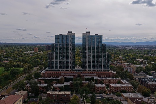 Aerial view of the twin high rise residential towers in the Cherry Creek neighborhood surrounded by lush trees and urban landscape in Denver Colorado United States. Aerial view of the twin high rise residential towers in the Cherry Creek neighborhood surrounded by lush trees and urban landscape in Denver Colorado United States.