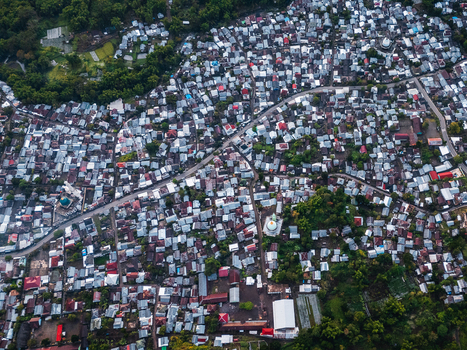 Aerial view of the dense village of Sembalun in an agricultural basin at the foothills of Mount Rinjani with metal rooftops and winding roads in Sembalun West Nusa Tenggara Indonesia. Aerial view of the dense village of Sembalun in an agricultural basin at the foothills of Mount Rinjani with metal rooftops and winding roads in Sembalun West Nusa Tenggara Indonesia.