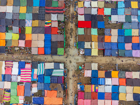 Tongi Bangladesh 31 January 2025 Aerial view of colorful square tents and canopies arranged in a grid pattern with people walking along the dirt paths during a large gathering. Tongi Bangladesh 31 January 2025 Aerial view of colorful square tents and canopies arranged in a grid pattern with people walking along the dirt paths during a large gathering.