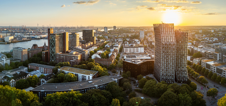 Hamburg Germany 24 August 2026 Aerial view of the Dancing Towers and the surrounding urban landscape of Hamburg featuring modern architecture green trees and the port area at sunset.