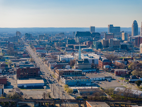 Aerial view of the Louisville skyline featuring urban streets historic church steeples and modern skyscrapers under a clear blue sky in Louisville Kentucky United States. Aerial view of the Louisville skyline featuring urban streets historic church steeples and modern skyscrapers under a clear blue sky in Louisville Kentucky United States.