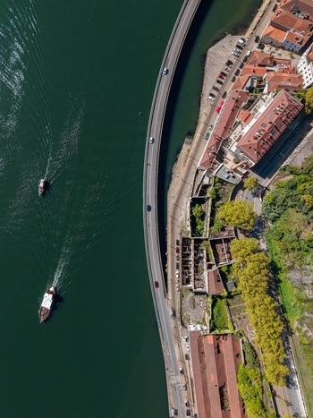 Aerial view of Viaduto do Cais das Pedras along the Douro River with boats on the water and historic buildings on the bank in Porto Porto Portugal.