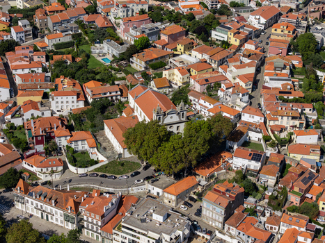 Aerial view of Igreja de Sao Joao Baptista da Foz do Douro surrounded by dense residential rooftops narrow streets and lush green trees in Porto Porto Portugal.