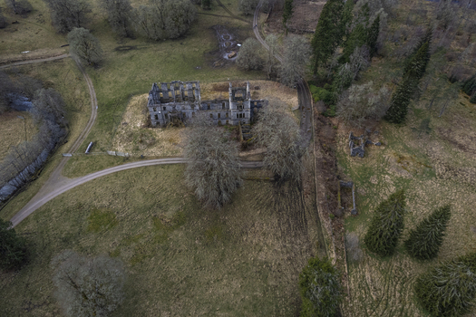 Aerial view of the ruins of Guisachan Historic House surrounded by trees and rural landscape in Beauly Glen Affric Scotland United Kingdom. Aerial view of the ruins of Guisachan Historic House surrounded by trees and rural landscape in Beauly Glen Affric Scotland United Kingdom.