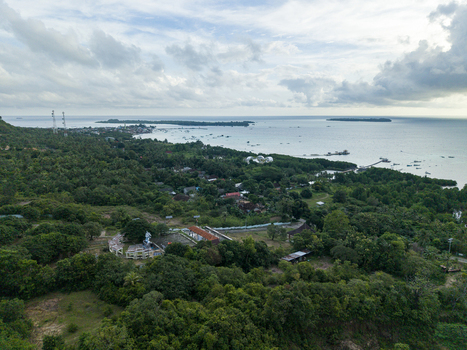 Aerial view of lush green forests stretching to the coastline meeting the tranquil blue sea near Bukit Love Karimunjawa Jawa Tengah Indonesia. Aerial view of lush green forests stretching to the coastline meeting the tranquil blue sea near Bukit Love Karimunjawa Jawa Tengah Indonesia.