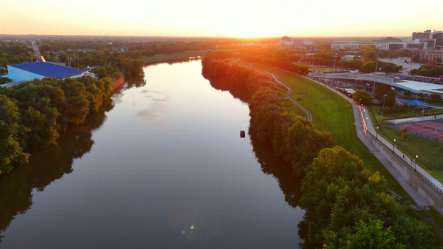 Aerial view of the White River at sunset with lush green banks and urban infrastructure in Indianapolis Indiana United States. Aerial view of the White River at sunset with lush green banks and urban infrastructure in Indianapolis Indiana United States.