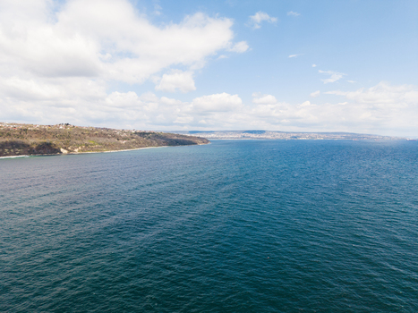 Aerial view of the rugged coastline of Fichoza Beach Veteran with deep blue sea and forested cliffs under a cloudy sky in Varna Varna Bulgaria. Aerial view of the rugged coastline of Fichoza Beach Veteran with deep blue sea and forested cliffs under a cloudy sky in Varna Varna Bulgaria.