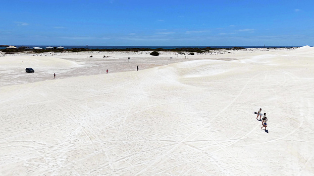 Aerial view of Lancelin Sand Dunes with white sand tire tracks and people walking under a clear blue sky in Lancelin Western Australia Australia. Aerial view of Lancelin Sand Dunes with white sand tire tracks and people walking under a clear blue sky in Lancelin Western Australia Australia.