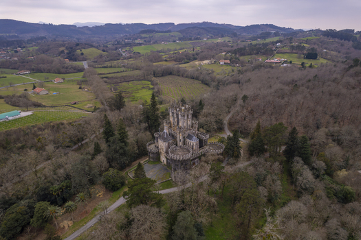 Aerial view of Butron Castle surrounded by lush forest and rolling hills in the Basque Country Butroi Euskadi Spain. Aerial view of Butron Castle surrounded by lush forest and rolling hills in the Basque Country Butroi Euskadi Spain.