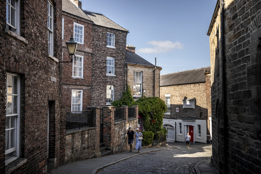 Durham England United Kingdom 13 July 2026 View of a historic cobblestone street in Durham with traditional brick buildings lush greenery and people walking on a sunny day. Durham England United Kingdom 13 July 2026 View of a historic cobblestone street in Durham with traditional brick buildings lush greenery and people walking on a sunny day.