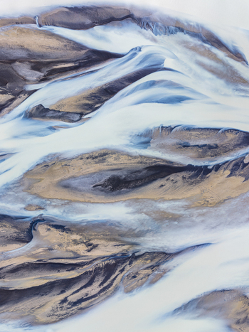 Aerial view of a braided river system with glacial meltwater flowing through volcanic sandbars and sediment deposits in Iceland. Aerial view of a braided river system with glacial meltwater flowing through volcanic sandbars and sediment deposits in Iceland.