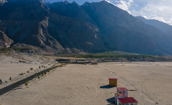 Aerial view of Sarfaranga Cold Desert Shigar with its vast sandy landscape rugged mountain backdrop and a small road leading through the arid terrain Skardu Gilgit Pakistan. Aerial view of Sarfaranga Cold Desert Shigar with its vast sandy landscape rugged mountain backdrop and a small road leading through the arid terrain Skardu Gilgit Pakistan.