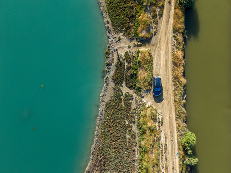 Aerial view of the Kanali i Vivarit with a car parked on a narrow dirt path between turquoise and murky green waters in Vrine Vlore County Albania. Aerial view of the Kanali i Vivarit with a car parked on a narrow dirt path between turquoise and murky green waters in Vrine Vlore County Albania.