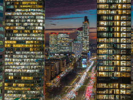 Aerial view of illuminated skyscrapers and heavy traffic on city streets at twilight in the business district of Warsaw Poland. Aerial view of illuminated skyscrapers and heavy traffic on city streets at twilight in the business district of Warsaw Poland.