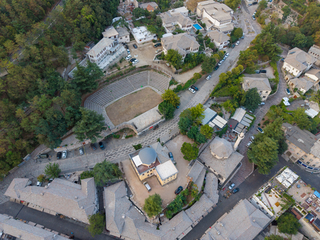 Aerial view of the historic stone architecture traditional rooftops old bazaar and open air theater in Gjirokaster Gjirokaster County Albania. Aerial view of the historic stone architecture traditional rooftops old bazaar and open air theater in Gjirokaster Gjirokaster County Albania.