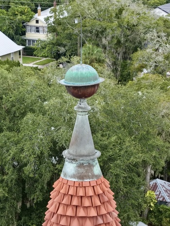 Aerial view of the copper spire and red tiled roof of Grace United Methodist Church surrounded by lush green trees in St. Augustine Florida United States. Aerial view of the copper spire and red tiled roof of Grace United Methodist Church surrounded by lush green trees in St. Augustine Florida United States.