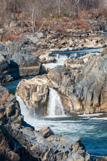 View of cascading water plunging over jagged rocks creating a dazzling display of nature s force and beauty in Great Falls National Park Virginia United States. View of cascading water plunging over jagged rocks creating a dazzling display of nature s force and beauty in Great Falls National Park Virginia United States.