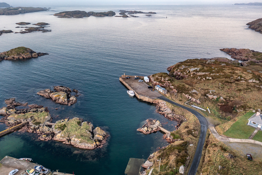 Aerial view of the rocky coastline and small harbour with moored boats surrounded by the Atlantic Ocean in Kincasslagh County Donegal Ireland. Aerial view of the rocky coastline and small harbour with moored boats surrounded by the Atlantic Ocean in Kincasslagh County Donegal Ireland.
