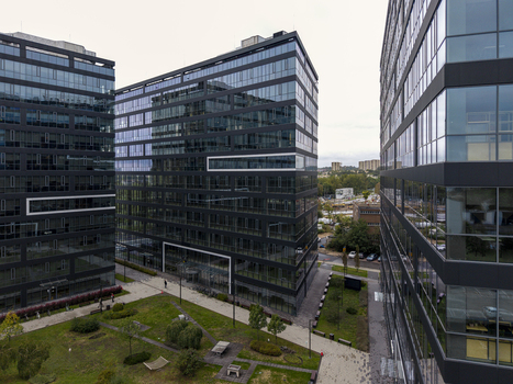 Aerial view of modern glass office buildings in a business park with landscaped green spaces and walkways in Krakow Lesser Poland Voivode Poland.