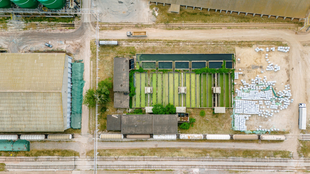 Aerial view of industrial facility featuring green settling tanks warehouses and railway tracks with freight cars in an industrial zone Sabac Vojvodina Serbia. Aerial view of industrial facility featuring green settling tanks warehouses and railway tracks with freight cars in an industrial zone Sabac Vojvodina Serbia.