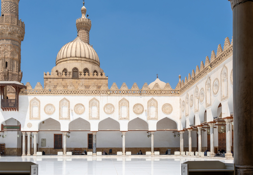 View of the historic courtyard of Al Azhar Mosque with its elegant white arches and stone dome under a clear blue sky in Cairo Egypt. View of the historic courtyard of Al Azhar Mosque with its elegant white arches and stone dome under a clear blue sky in Cairo Egypt.