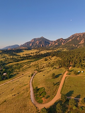 Aerial view of the NCAR and UCAR Foothills Laboratory nestled in the foothills with winding roads grassy slopes and pine trees in Boulder Colorado United States.
