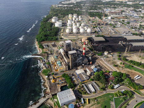 Aerial view of the industrial zone and power plant facilities along the coastline with storage tanks and chimneys in Bajos de Haina San Cristobal Province Dominican Republic.