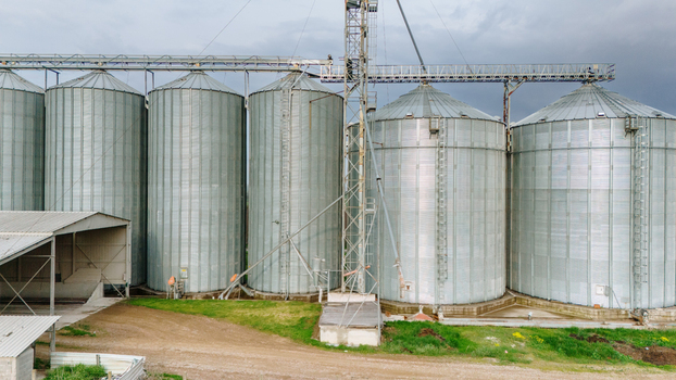 Aerial view of towering metallic grain silos gleaming under a cloudy sky a testament to agricultural prowess Sremska Mitrovica Vojvodina Serbia. Aerial view of towering metallic grain silos gleaming under a cloudy sky a testament to agricultural prowess Sremska Mitrovica Vojvodina Serbia.