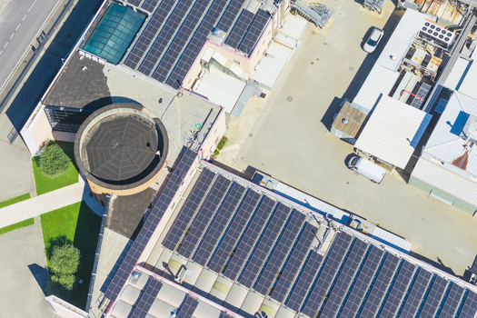 Aerial view of industrial buildings with extensive solar panel arrays on the rooftops featuring a circular structure and surrounding paved areas in Arezzo Tuscany Italy. Aerial view of industrial buildings with extensive solar panel arrays on the rooftops featuring a circular structure and surrounding paved areas in Arezzo Tuscany Italy.