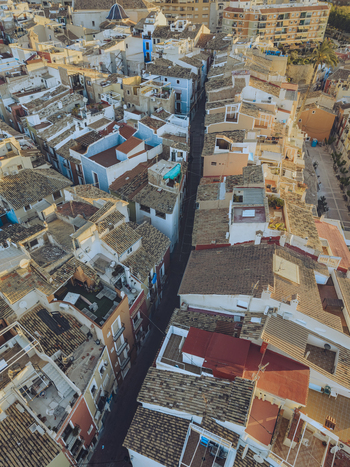 Aerial view of the colorful houses and narrow streets in the historic old town with terracotta rooftops under warm sunlight in La Vila Joiosa Valencian Community Spain. Aerial view of the colorful houses and narrow streets in the historic old town with terracotta rooftops under warm sunlight in La Vila Joiosa Valencian Community Spain.