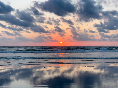 View of Strand Wijk aan Zee at sunset with cloudy sky reflecting on the wet shoreline in Wijk aan Zee North Holland Netherlands. View of Strand Wijk aan Zee at sunset with cloudy sky reflecting on the wet shoreline in Wijk aan Zee North Holland Netherlands.