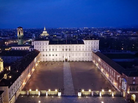 Aerial view of the illuminated Royal Palace of Turin and the city skyline at twilight with the Mole Antonelliana in the background in Turin Piedmont Italy.