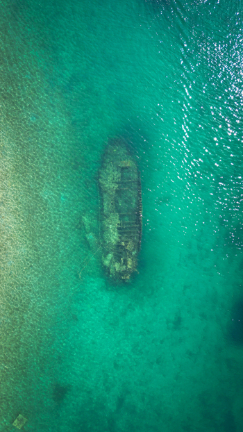 Aerial view of the submerged Kontesa shipwreck resting in clear turquoise waters of the Adriatic Sea in Necujam Split Dalmatia County Croatia. Aerial view of the submerged Kontesa shipwreck resting in clear turquoise waters of the Adriatic Sea in Necujam Split Dalmatia County Croatia.
