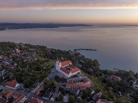 Aerial view of Tihanyi Bences Apatsag overlooking Lake Balaton at sunset with historic buildings and lush trees in Tihany Hungary. Aerial view of Tihanyi Bences Apatsag overlooking Lake Balaton at sunset with historic buildings and lush trees in Tihany Hungary.