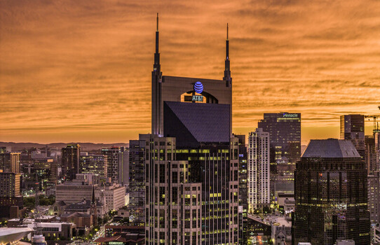 Aerial view of the ATT Building also known as the Batman Building in downtown Nashville at sunset with city skyscrapers and warm golden light Nashville TN United States.