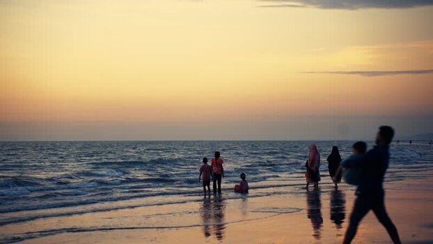 View of people walking on the beach at sunset Bangladesh.